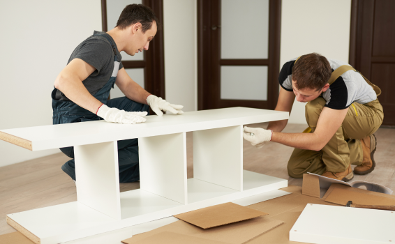 Delivery men assembling furniture at customers home