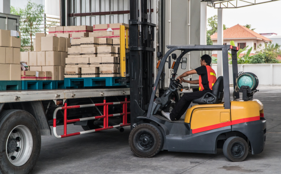 Forklift loading a flatbed with packages