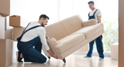 Workers moving a couch into a nice home